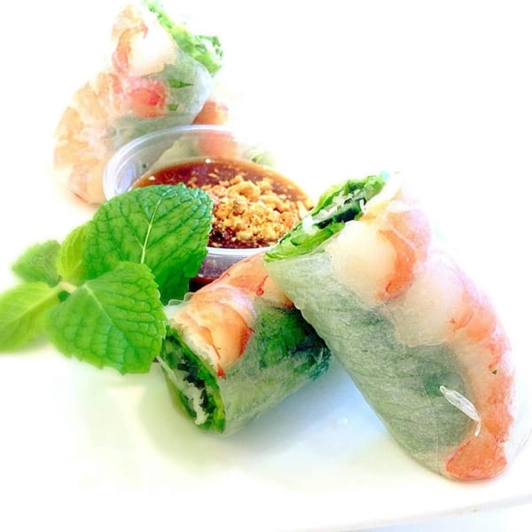 Fresh Vietnamese spring rolls with shrimp, lettuce, and herbs, served with peanut dipping sauce and mint.