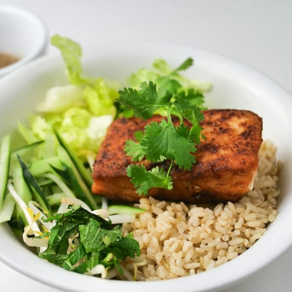 Vietnamese bowl with crispy tofu, brown rice, fresh cilantro, lettuce, cucumber, and bean sprouts.